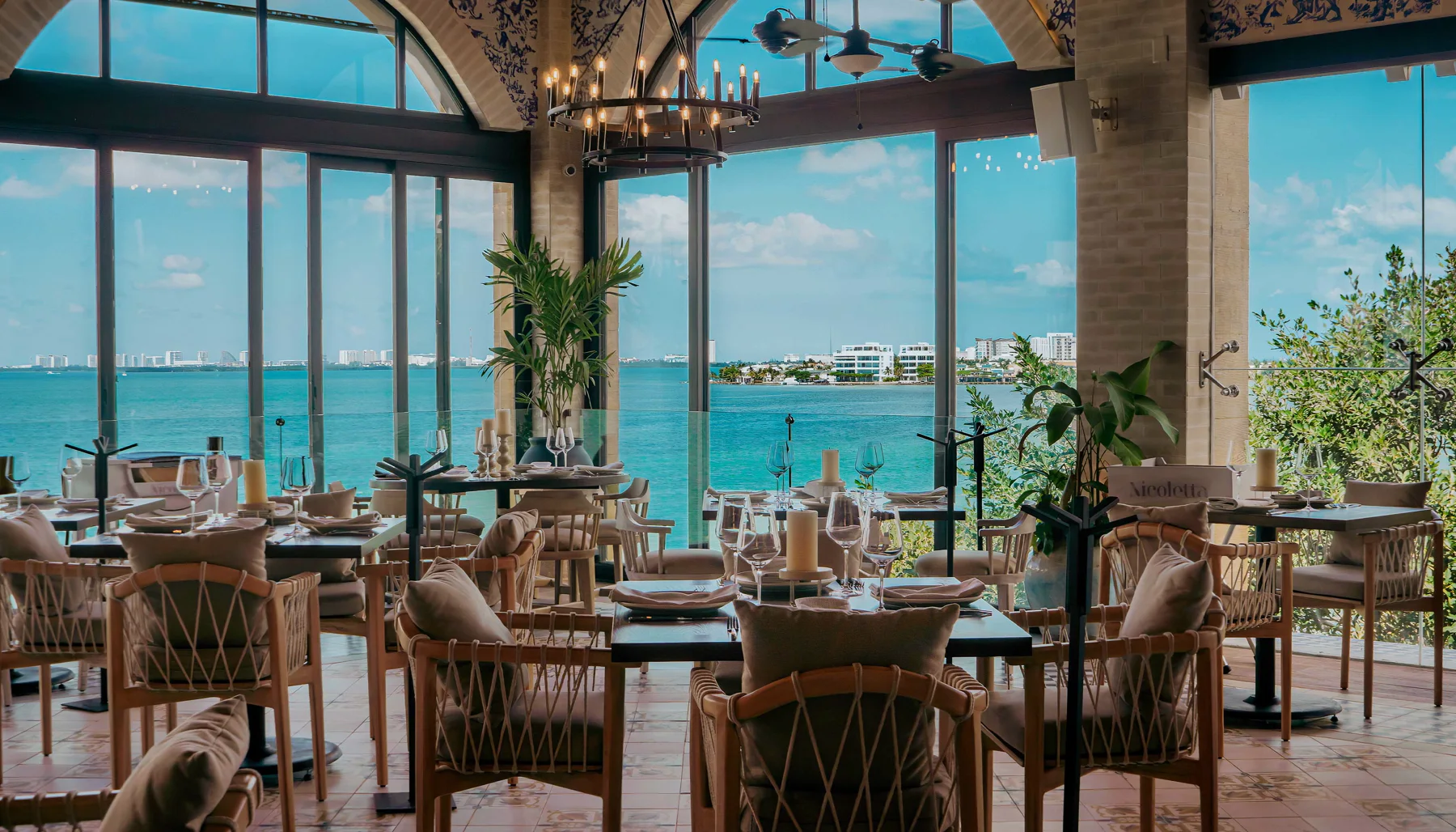 The glass dining room of Nicoletta Cancún over the lagoon