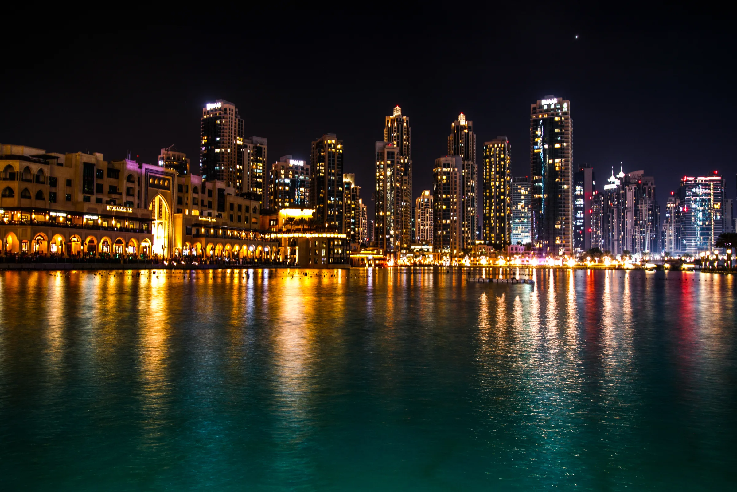 Downtown Dubai at night, the towers reflected in the Burj Lake