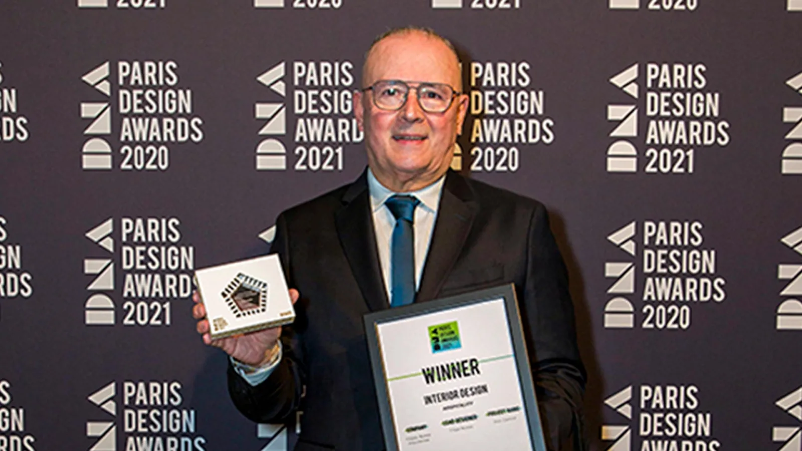 The award of the DNA Paris Design Awards being received in front of the event backdrop